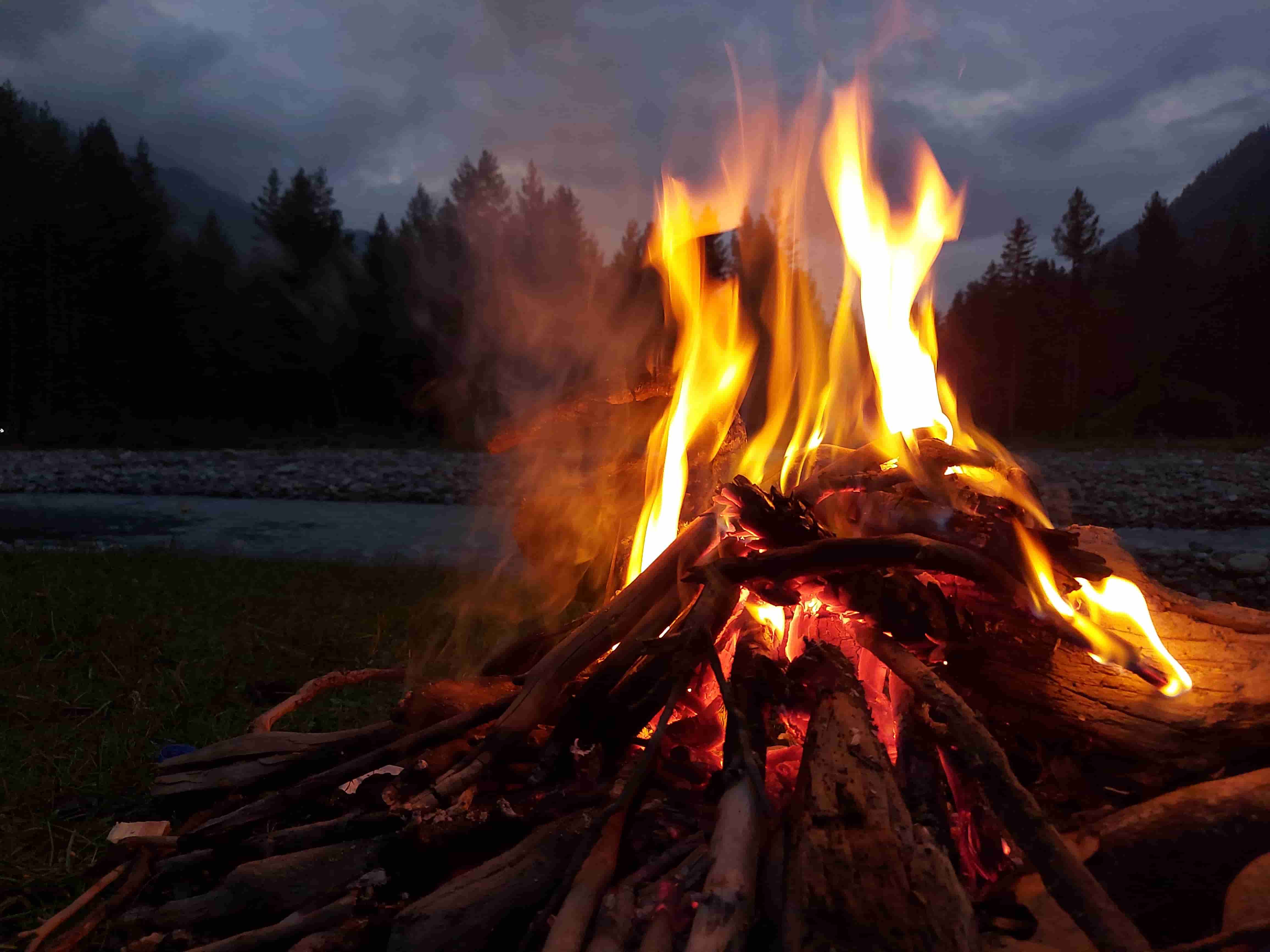 Bonfire camping experience with group around fire at night